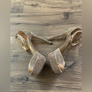 Aldo gold metallic platforms with clear ankle straps with gold trim.